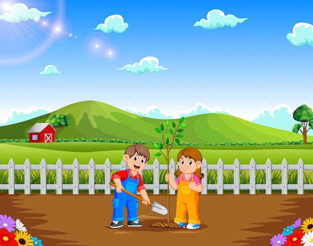 Boy and girl planting tree in the park