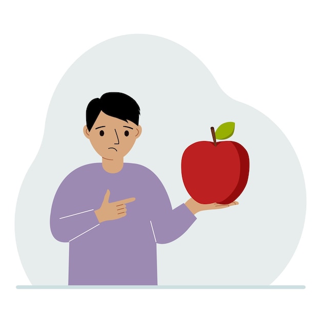 A boy holds a fresh and red apple in his hand Boy eats an apple Healthy food concept