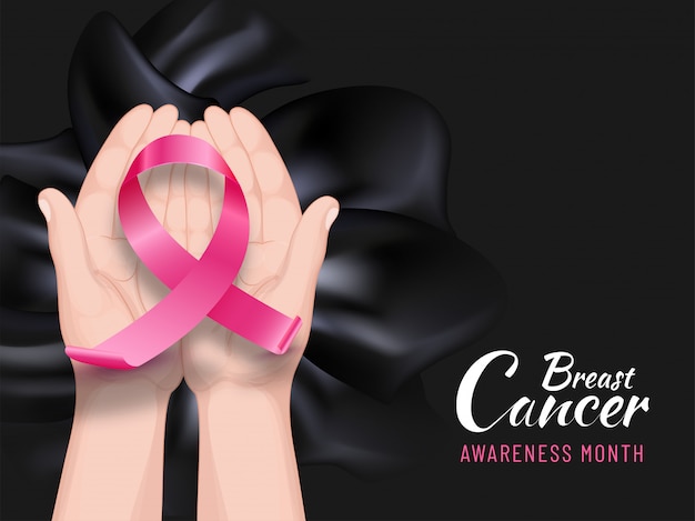 Insegna o manifesto di mese di consapevolezza del cancro al seno con le mani umane che tengono nastro rosa su tessuto di seta nero.