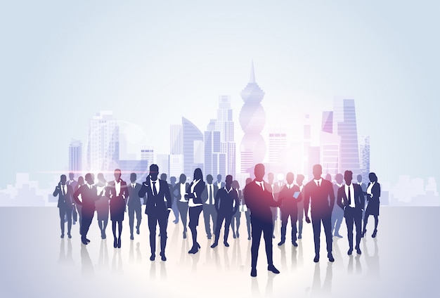 Business people group silhouettes over city landscape modern office buildings