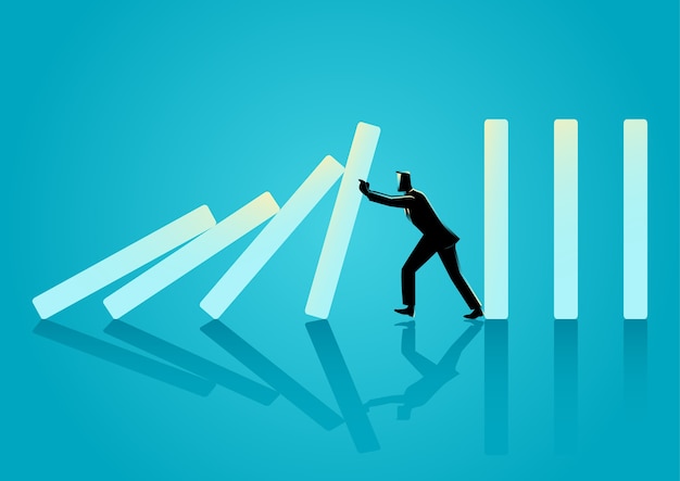 businessman trying to stop domino effect
