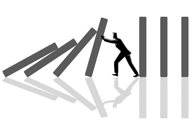 businessman trying to stop domino effect