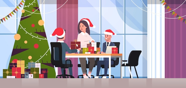 businesswoman congratulating male colleagues with merry christmas happy new year holidays businesspeople at workplace holding gift present boxes modern office interior