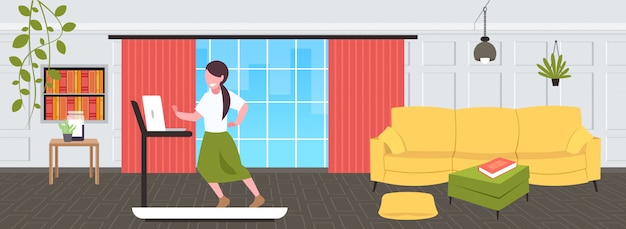 Businesswoman using laptop running on treadmill woman freelancer workout hard working concept modern living room interior  full length horizontal
