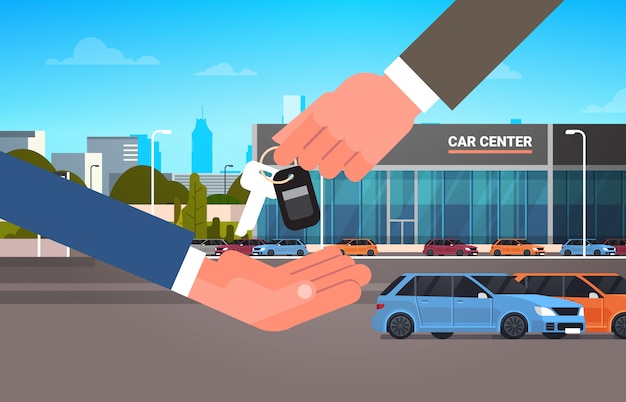 Car purchase sale or rental concept, seller man hand giving keys to owner showroom center