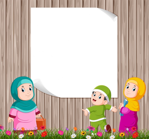 The children are standing and playing with their mother near the blank board