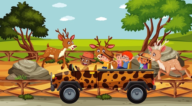 Children group at the zoo with many deers