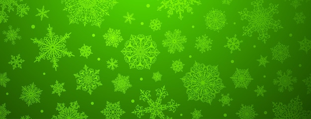 緑の色で大小の複雑な雪片のクリスマスの背景