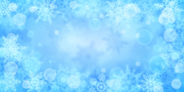 Christmas background of blurry snowflakes in light blue colors