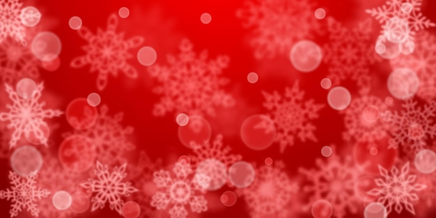 Christmas background of blurry snowflakes in red colors