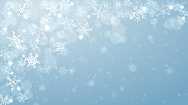 Christmas background of complex blurred and clear falling snowflakes in light blue colors with bokeh effect