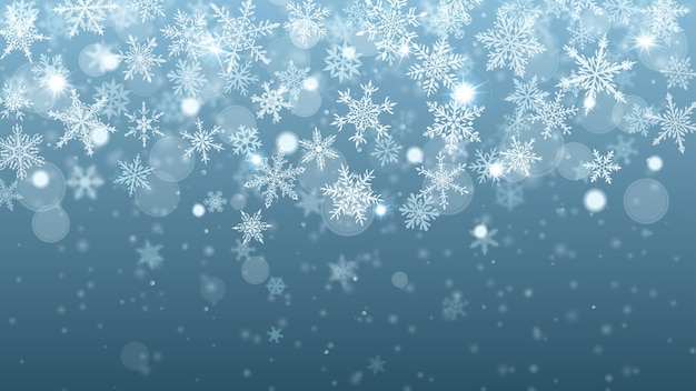 Christmas background of complex blurred and clear falling snowflakes in light blue colors with bokeh effect