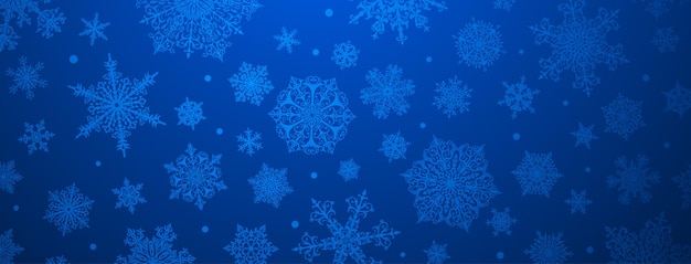 青い色の大小の複雑な雪片のクリスマス背景