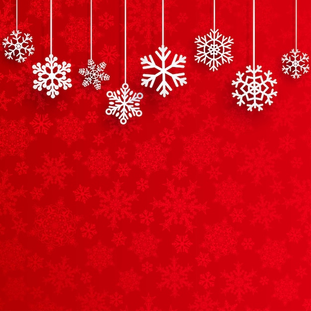 Christmas background with several hanging snowflakes on red background of small snowflakes