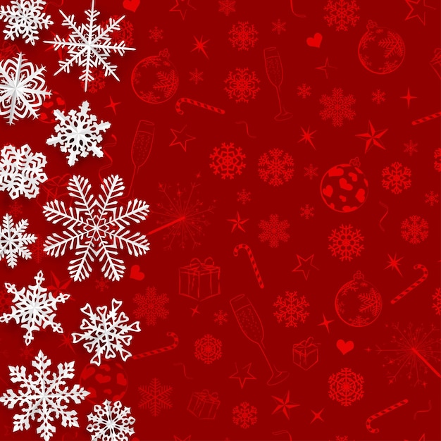 Christmas background with snowflakes cut out of paper on red background of Christmas symbols