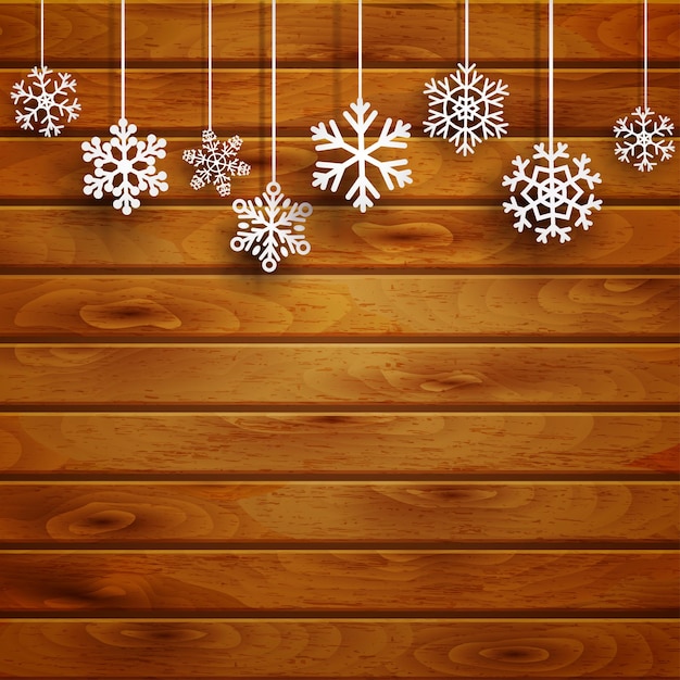 Christmas background with white hanging snowflakes on brown wooden planks