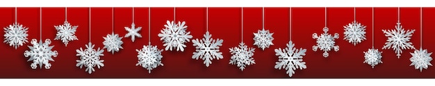Christmas banner of large white complex paper hanging snowflakes on red background