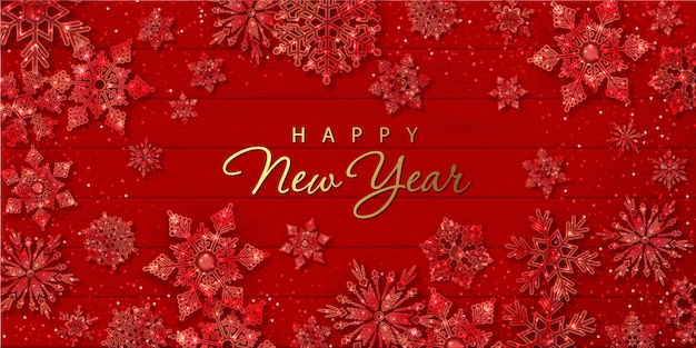 Christmas and New Year banner with sparkling glass snowflakes on red wooden background