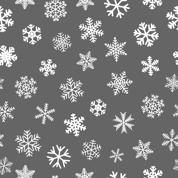 灰色の背景に白い雪片のクリスマスのシームレスなパターン