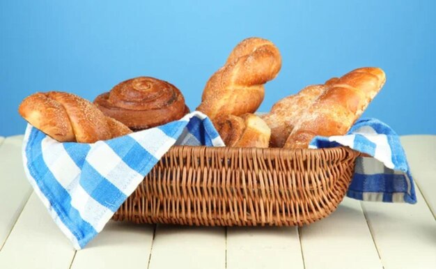 Compositie met broodjes in een vliezen mand op een houten tafel