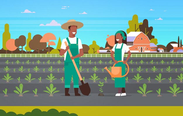 Couple farmers planting seedlings plants vegetables   man woman gardeners using shovel watering can eco farming concept farmland countryside landscape horizontal