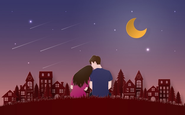 Couple sitting on grass floor looking meteor