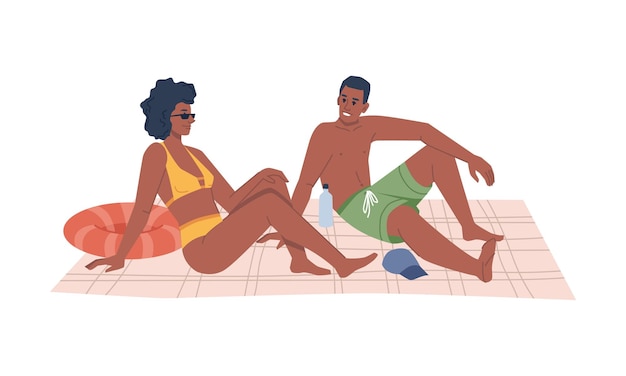 Couple in swimsuits sitting on blanket on beach