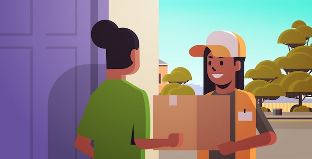 женщина курьера поставляя картонную коробку пакета к Афро-американской девушке получателю на дому концепция курьерской службы доставки горизонтальная портрет