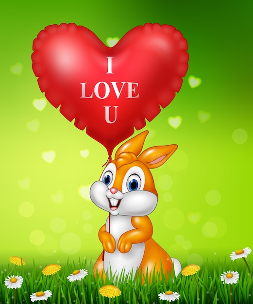 Cute bunny holding red heart balloons on green grass