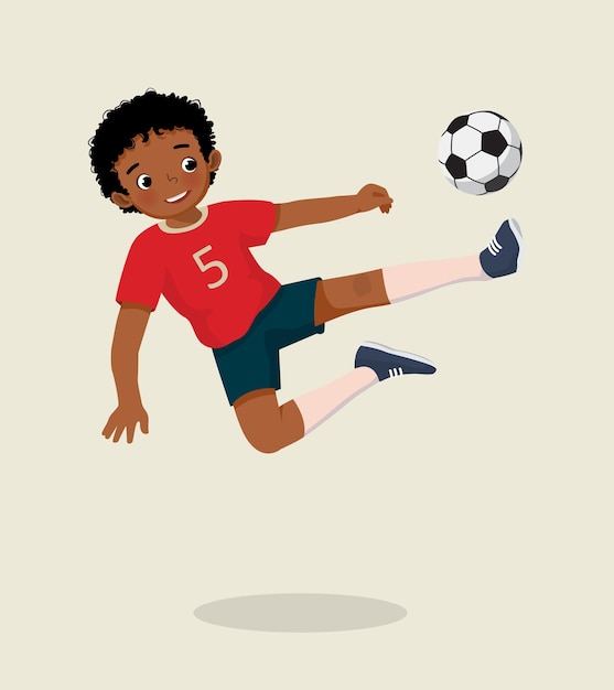 Милый маленький африканский мальчик, играющий в футбол, прыгает высоко, пинает мяч, чтобы забить гол