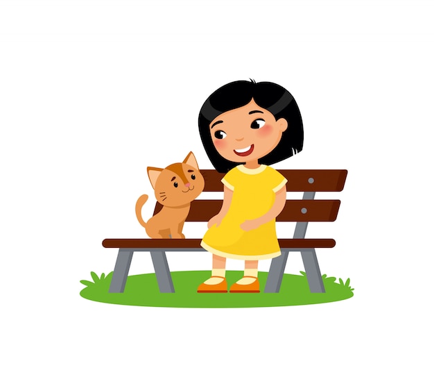 Милая маленькая азиатская девушка и котенок сидят на скамейке. Счастливый школьный или дошкольный ребенок и ее питомец, играя вместе.