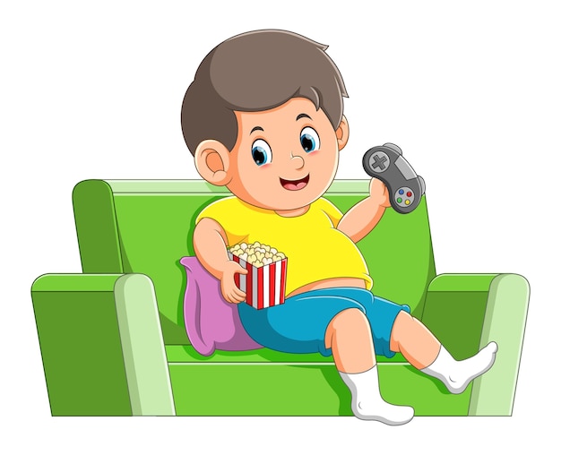 De gelukkige jongen speelt het spel en eet de popcorn op de bank