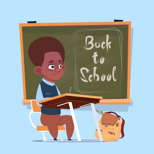 De kleine Afrikaanse Amerikaanse Schooljongen zit bij Bureau