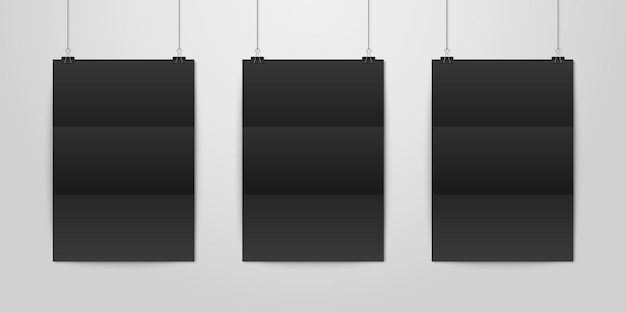 Drie realistische zwarte lege verticale a4 gevouwen papieren poster hangend aan een touw met bindclipset