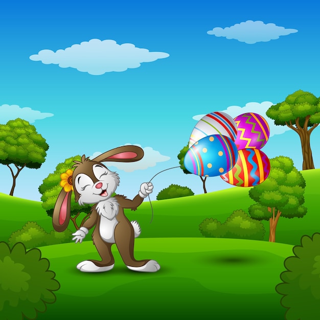 Easter bunny holding easter eggs balloons in the park