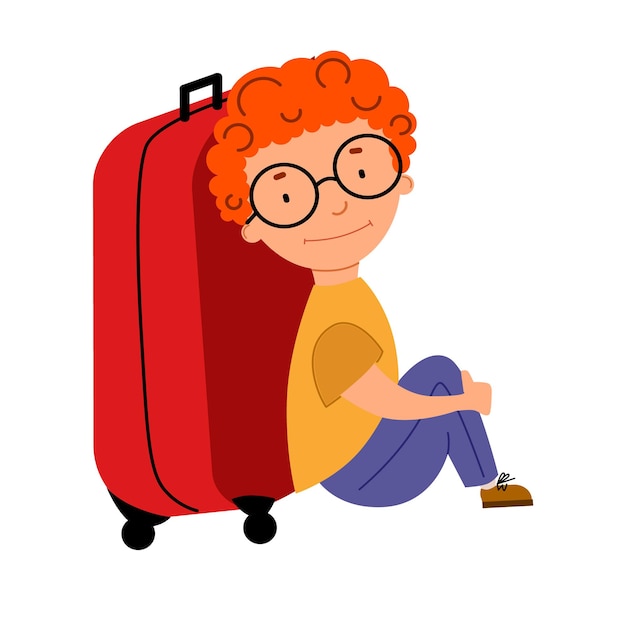 Een schattige roodharige jongen met krullend haar met een bril zit naast een koffer