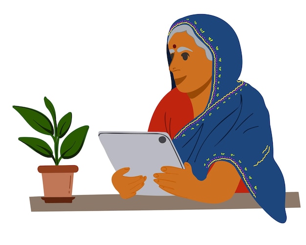 An elderly Indian woman sits at a table with a tablet.