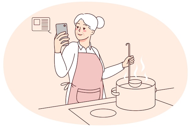 Donna anziana che cucina la zuppa in cucina con la ricetta online sul cellulare sorride moderna