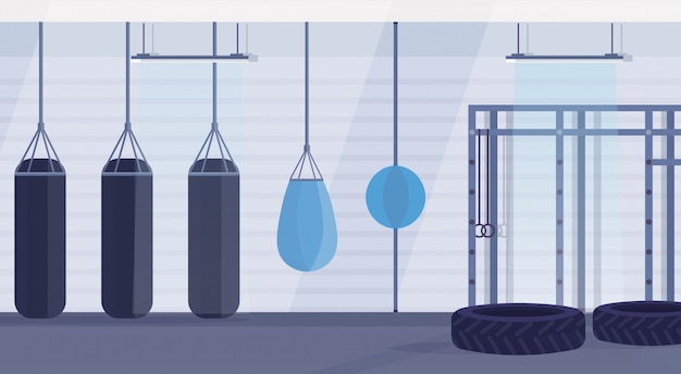 Empty boxing studio with punching bags of different shapes for practicing martial arts in gym modern fight club interior design horizontal banner flat