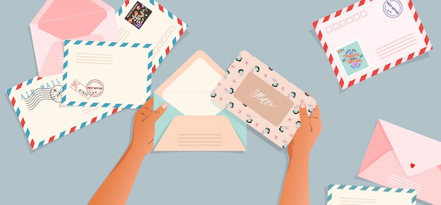 Vector envelopes and post cards on the table. hands holding an envelope. top down view. greeting card and a letter in a hand. modern  illustration for web  and print. retro cards and envelopes.