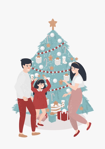 Familie met een kind danst in de buurt van de kerstboom
