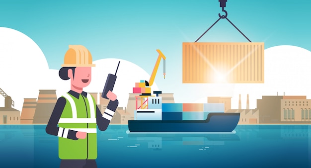 Female engineer using walkie-talkie controlling crane hook lifting cargo container box