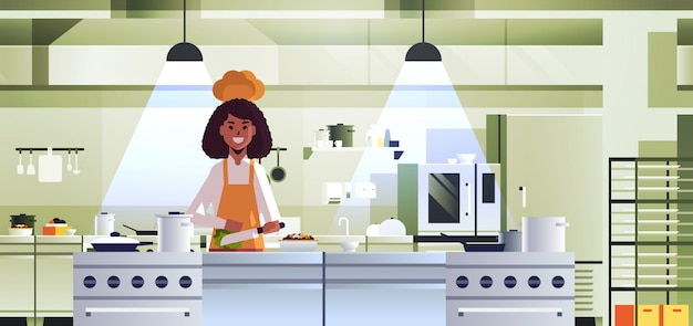 Female professional chef cook chopping vegetables on carving board african american woman in uniform preparing salad cooking food concept modern restaurant kitchen interior portrait horizontal