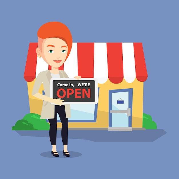 Female shop owner holding open signboard.