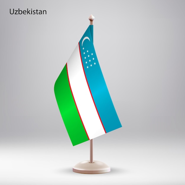 Vettore bandiera dell'uzbekistan appesa su un supporto per le bandiere