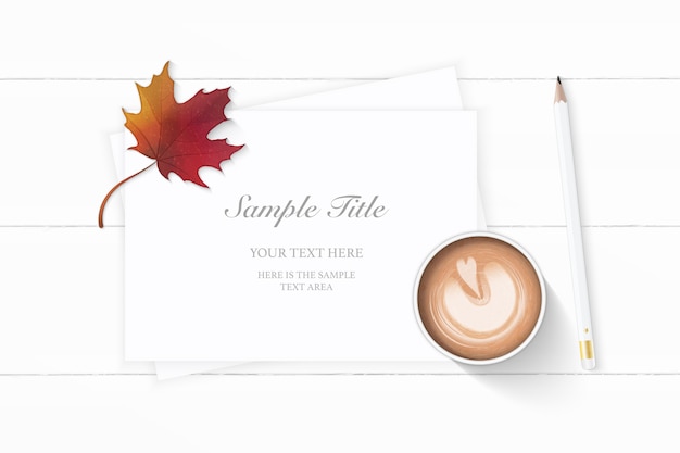 Flat lay top view elegant white Christmas composition paper pencil autumn maple leaf and coffee on wooden background.