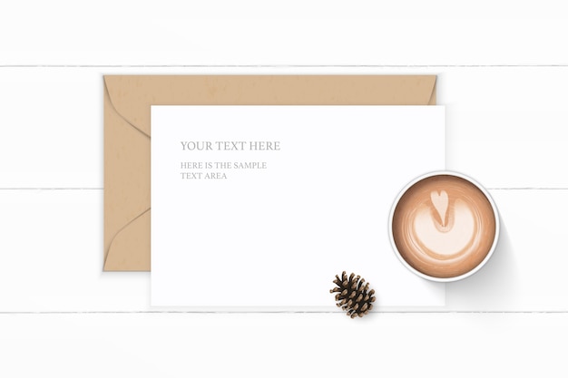 Flat lay top view elegant white composition letter kraft paper envelope pine cone and coffee on wooden background.