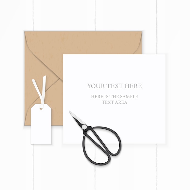 Flat lay top view elegant white composition paper brown kraft envelope tag and metal vintage scissors on wooden background.