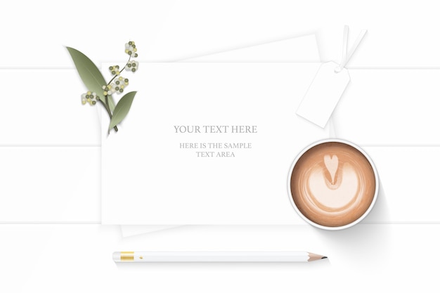 Flat lay top view elegant white composition paper plant leaf\
flower pencil and coffee on wooden background.