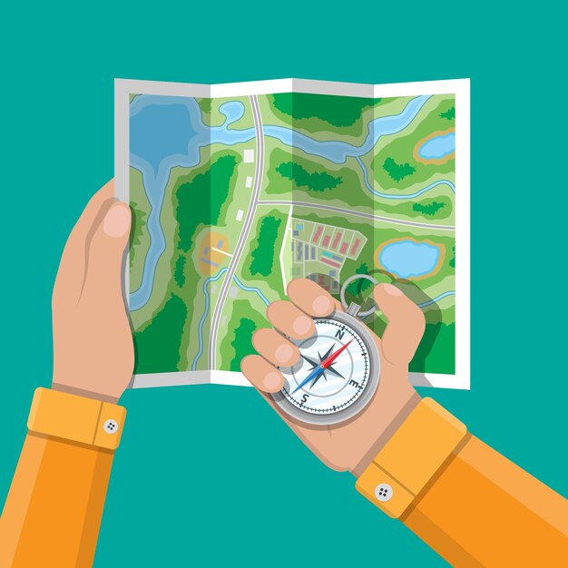 Folded paper city map and compass in hands